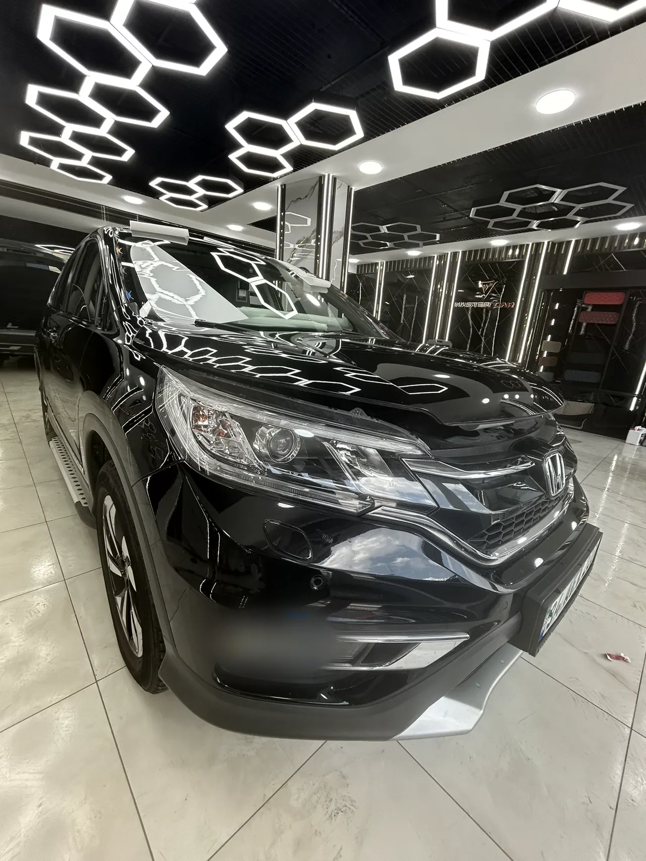 Stüdyoda PPF kaplamalı siyah SUV, altıgen aydınlatma